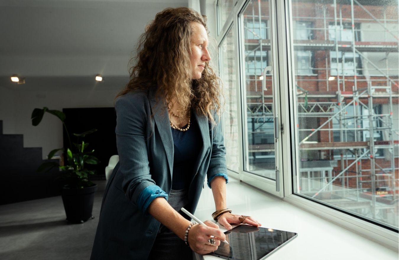 Kim Sabine Eichhorn blickt aus dem Bürofenster – Klarheit für neue Projekte.
